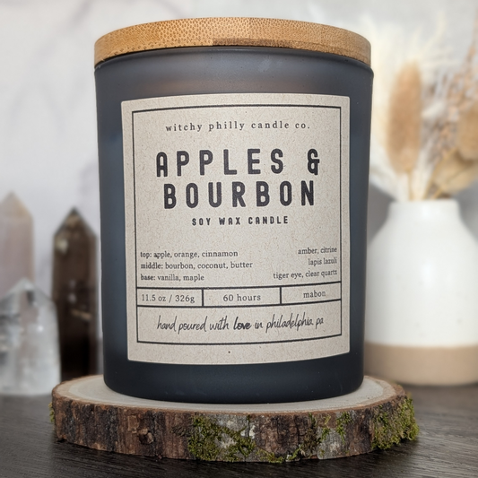 apples and bourbon candle on a wood slice with crystals and pampas grass in the background